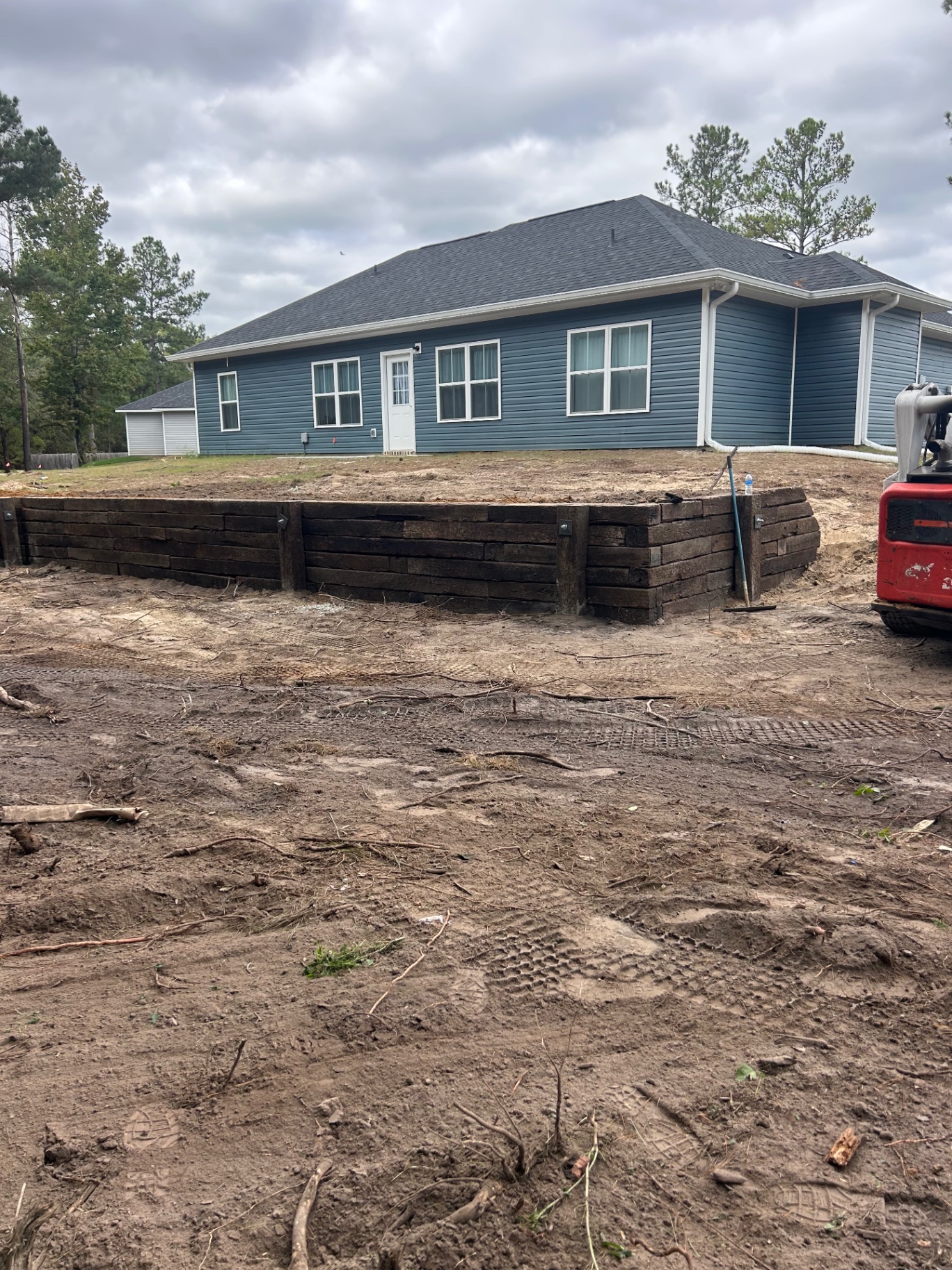 Crosstie retaining wall holding grade behind a home